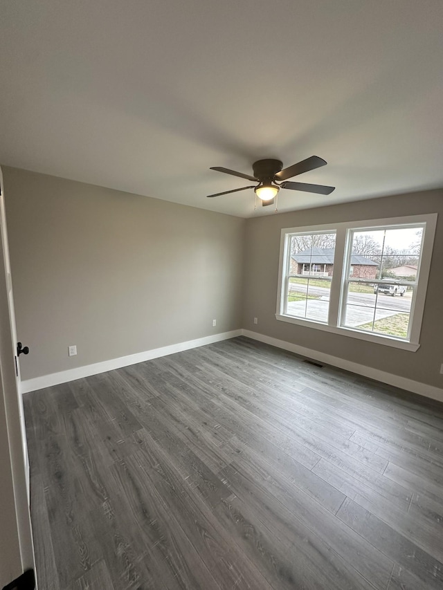 spare room with ceiling fan and dark hardwood / wood-style floors