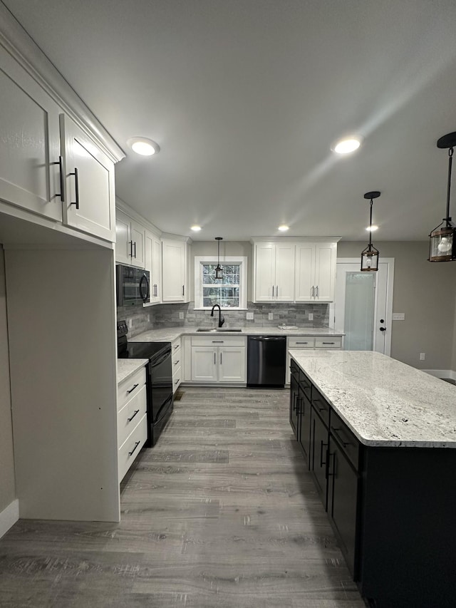 kitchen with black appliances, pendant lighting, white cabinetry, and sink