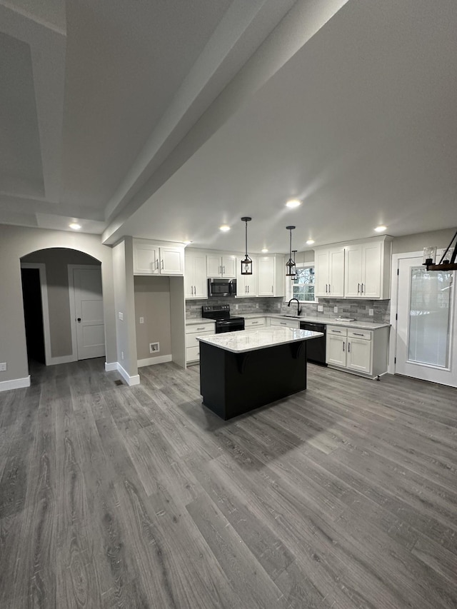 kitchen with sink, black appliances, a center island, white cabinetry, and hanging light fixtures