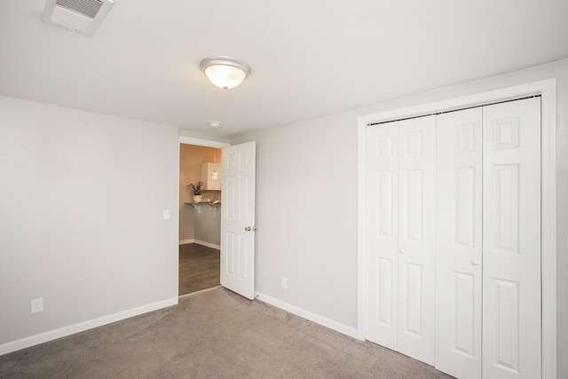 unfurnished bedroom featuring carpet flooring and a closet