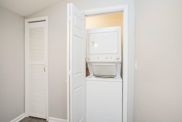 laundry room with hardwood / wood-style flooring and stacked washing maching and dryer