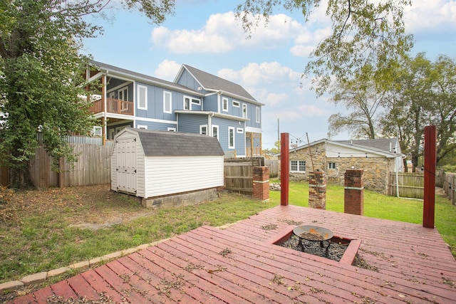 wooden deck featuring a lawn and a storage shed