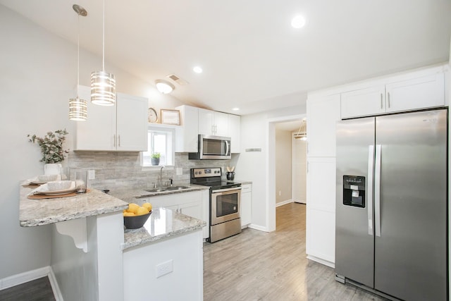 kitchen featuring white cabinetry, sink, stainless steel appliances, lofted ceiling, and decorative light fixtures