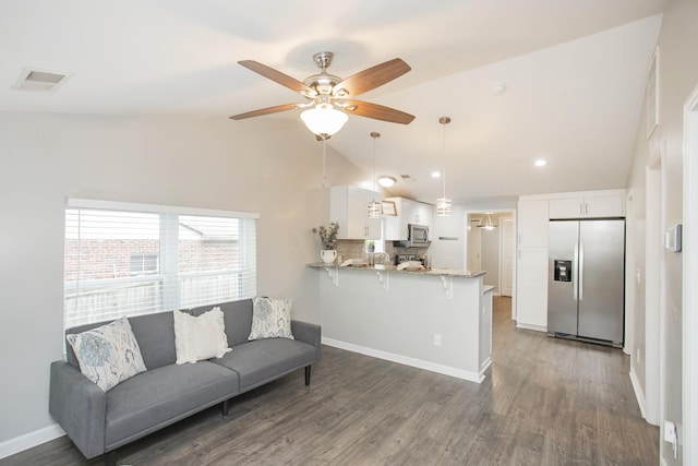 living room featuring ceiling fan, dark wood-type flooring, and vaulted ceiling