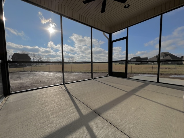 unfurnished sunroom featuring ceiling fan and a healthy amount of sunlight