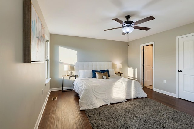 bedroom featuring ceiling fan, dark wood-type flooring, and multiple windows