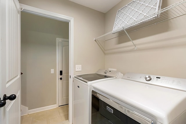 laundry area with light tile patterned floors and washing machine and clothes dryer