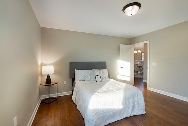 bedroom featuring dark hardwood / wood-style floors and an inviting chandelier