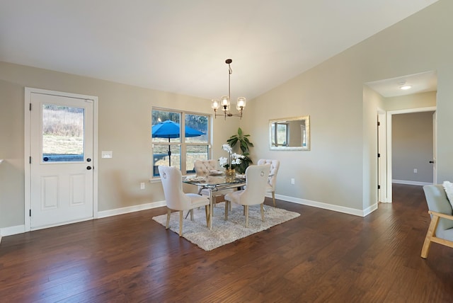 dining area featuring dark hardwood / wood-style flooring, an inviting chandelier, and lofted ceiling