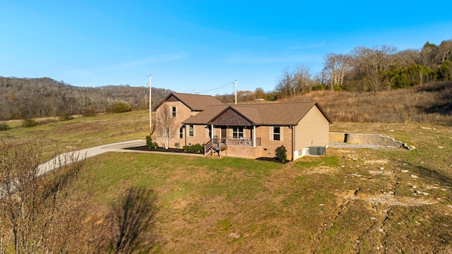 view of front of property with a porch, cooling unit, and a front yard