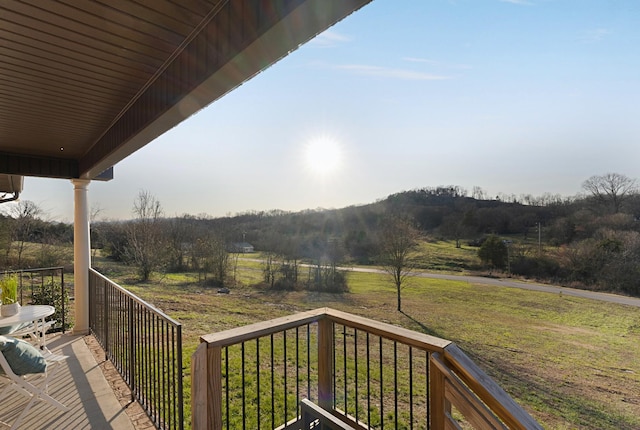 wooden deck with a yard and a rural view