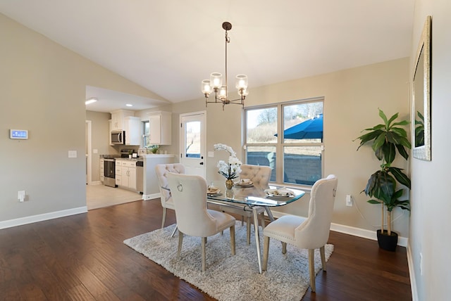 dining space with dark wood-type flooring, lofted ceiling, and a notable chandelier