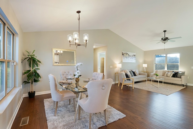 dining space with ceiling fan with notable chandelier, dark hardwood / wood-style floors, and lofted ceiling