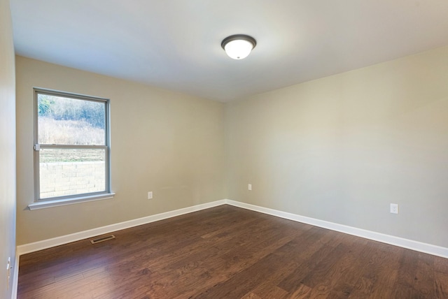 spare room featuring dark hardwood / wood-style flooring