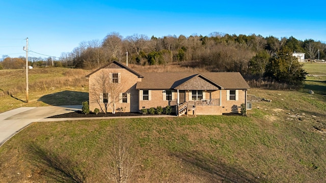 view of front of property featuring covered porch and a front lawn