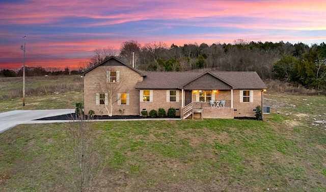 view of front of property featuring a lawn, cooling unit, and covered porch