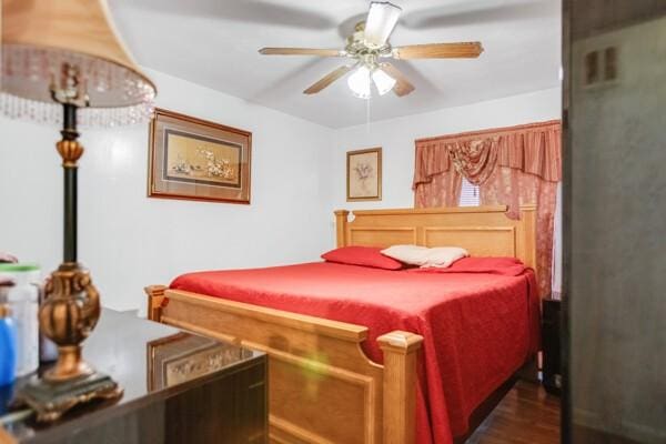 bedroom with ceiling fan and dark hardwood / wood-style flooring