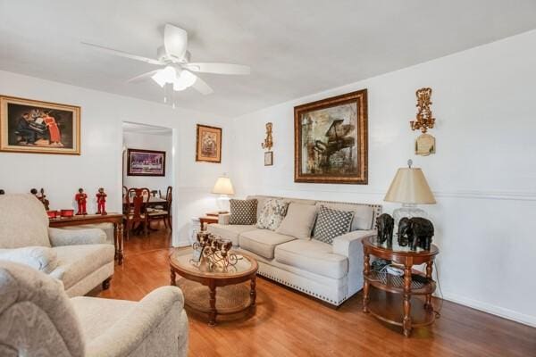 living room with wood-type flooring and ceiling fan