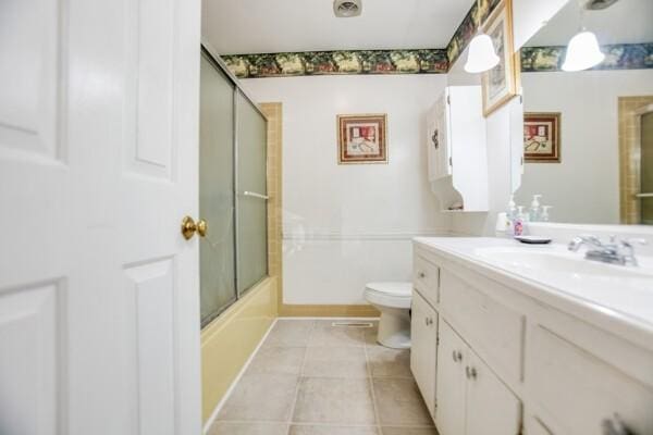 full bathroom featuring tile patterned flooring, vanity, bath / shower combo with glass door, and toilet