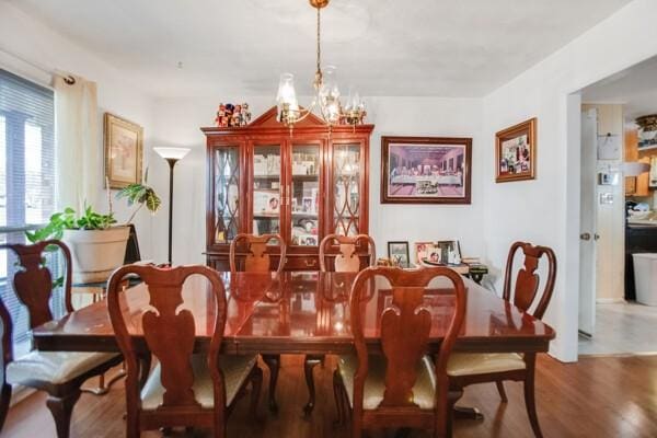 dining space featuring hardwood / wood-style floors and a notable chandelier