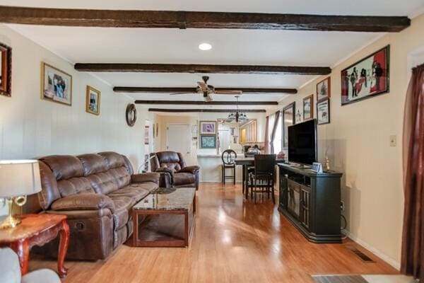 living room with ceiling fan, beamed ceiling, and light wood-type flooring