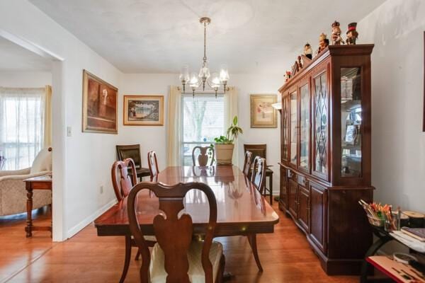 dining space featuring wood-type flooring and a chandelier