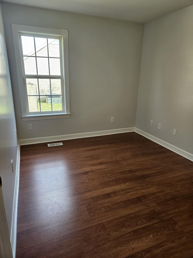 spare room with dark hardwood / wood-style floors