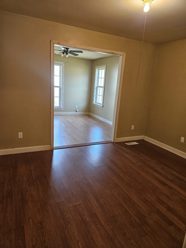 spare room with ceiling fan and dark wood-type flooring