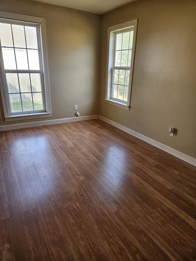 empty room with dark hardwood / wood-style flooring