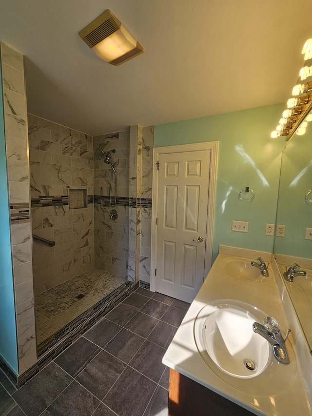 bathroom with tile patterned floors, vanity, and tiled shower