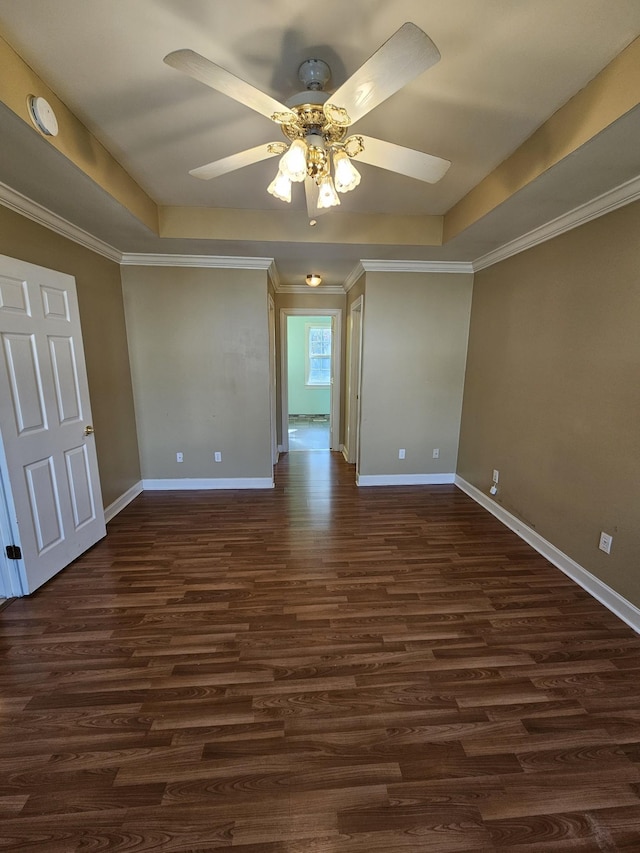 empty room featuring a tray ceiling, ceiling fan, and dark hardwood / wood-style flooring