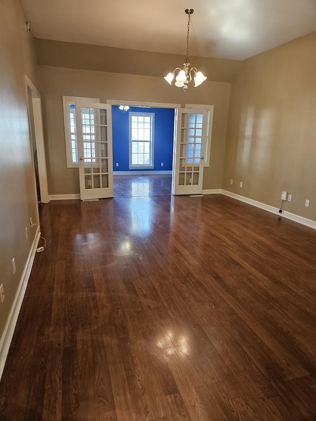 interior space featuring french doors, dark hardwood / wood-style flooring, lofted ceiling, and a notable chandelier