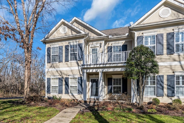 view of front of home featuring a balcony and a front lawn