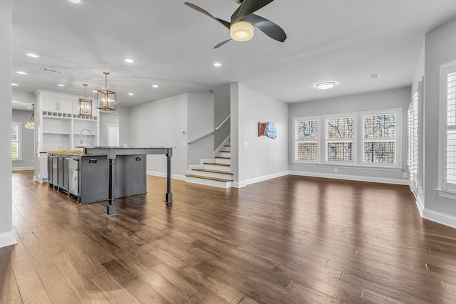 living room with ceiling fan, plenty of natural light, dark hardwood / wood-style floors, and sink