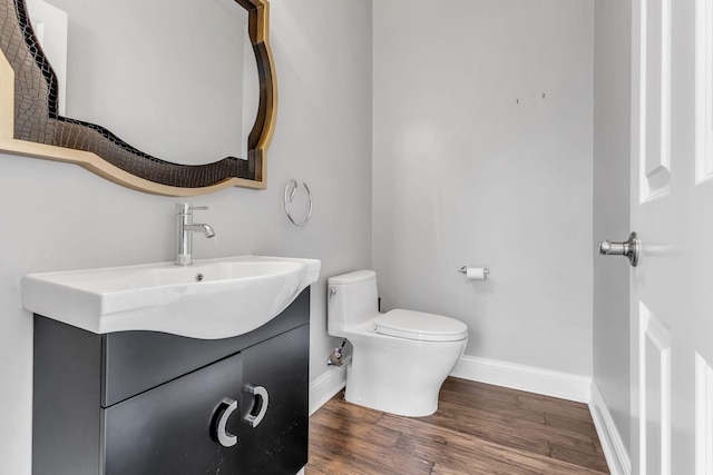 bathroom with hardwood / wood-style floors, vanity, and toilet