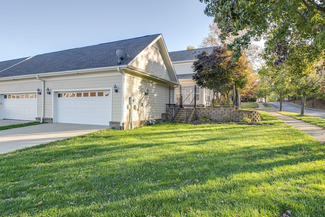 view of side of property featuring a garage and a lawn