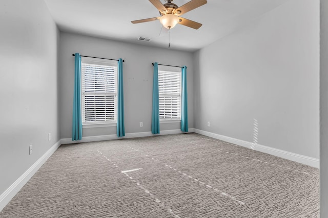 carpeted spare room with a wealth of natural light and ceiling fan