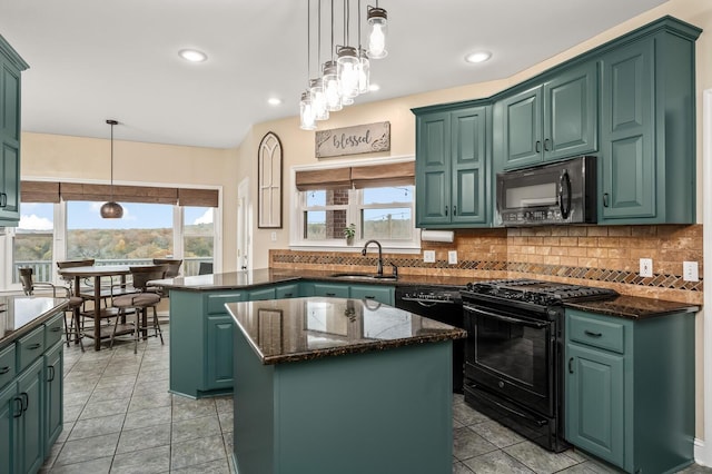 kitchen featuring pendant lighting, backsplash, black appliances, sink, and a kitchen island