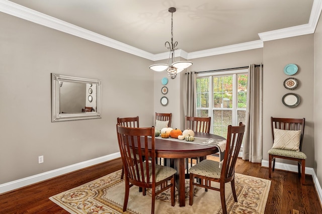 dining area featuring dark hardwood / wood-style floors and ornamental molding