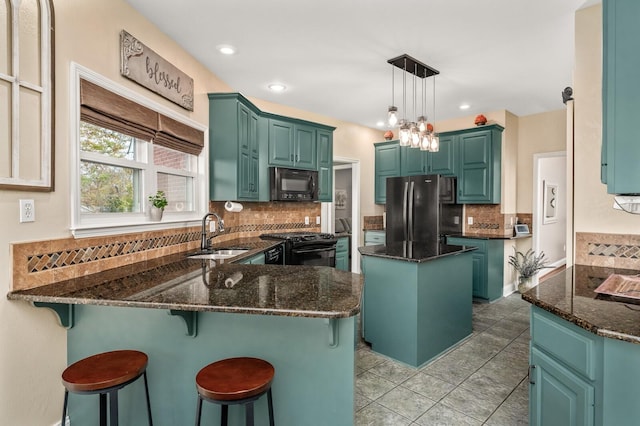 kitchen with sink, a kitchen island, dark stone countertops, and black appliances