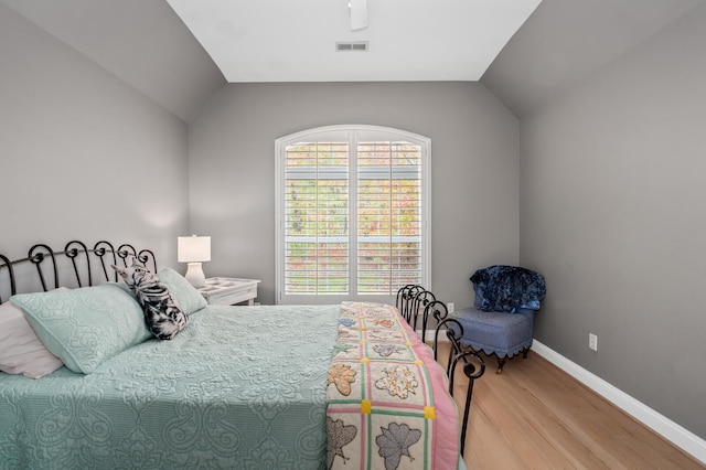 bedroom featuring hardwood / wood-style floors and lofted ceiling