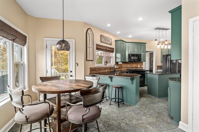 kitchen with black appliances, sink, hanging light fixtures, decorative backsplash, and kitchen peninsula