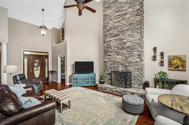 living room with ceiling fan, dark hardwood / wood-style flooring, a fireplace, and high vaulted ceiling