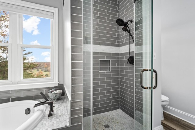 bathroom featuring shower with separate bathtub, toilet, and hardwood / wood-style floors