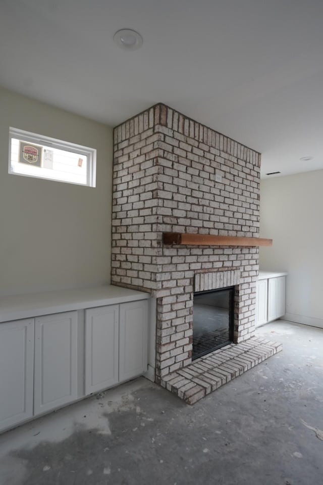 unfurnished living room with a brick fireplace