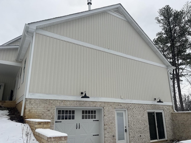 view of snowy exterior featuring a garage