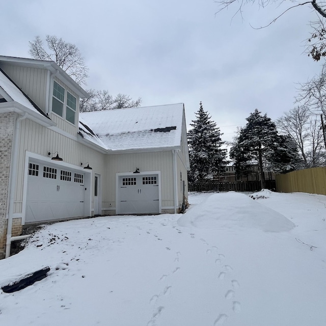 view of snow covered exterior with a garage