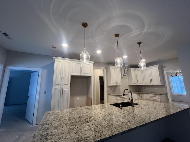 kitchen featuring white cabinetry, hanging light fixtures, and sink