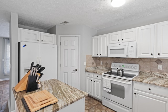 kitchen with white appliances, light stone counters, a textured ceiling, white cabinets, and decorative backsplash