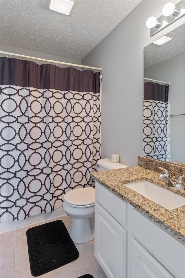 bathroom featuring vanity, toilet, tile patterned floors, a textured ceiling, and a shower with curtain